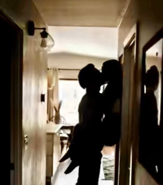 a man and woman are kissing in the hallway