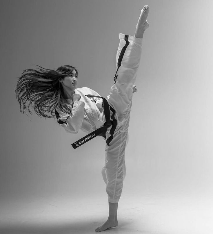 a woman doing a kickbox pose in black and white