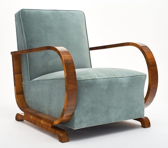 a blue chair with wooden frame and arm rests against a white background, it appears to be in the style of art deco