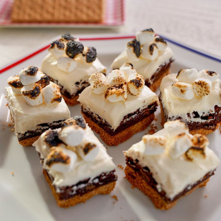 small desserts are arranged on a plate with white frosting and toppings,