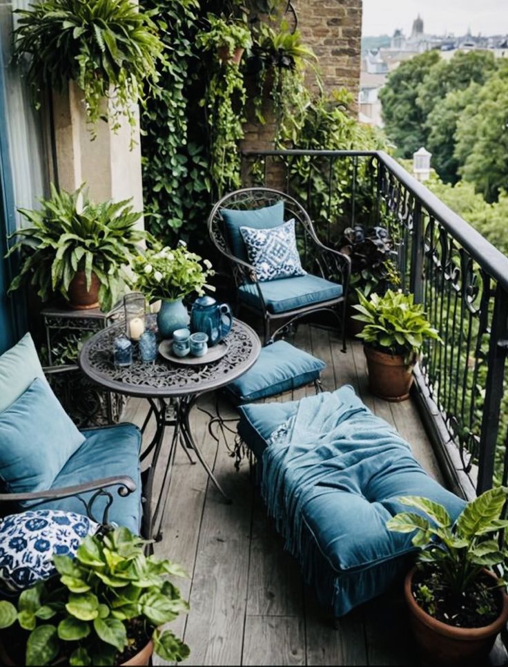 an outdoor patio with blue furniture and potted plants on the balcony, surrounded by greenery