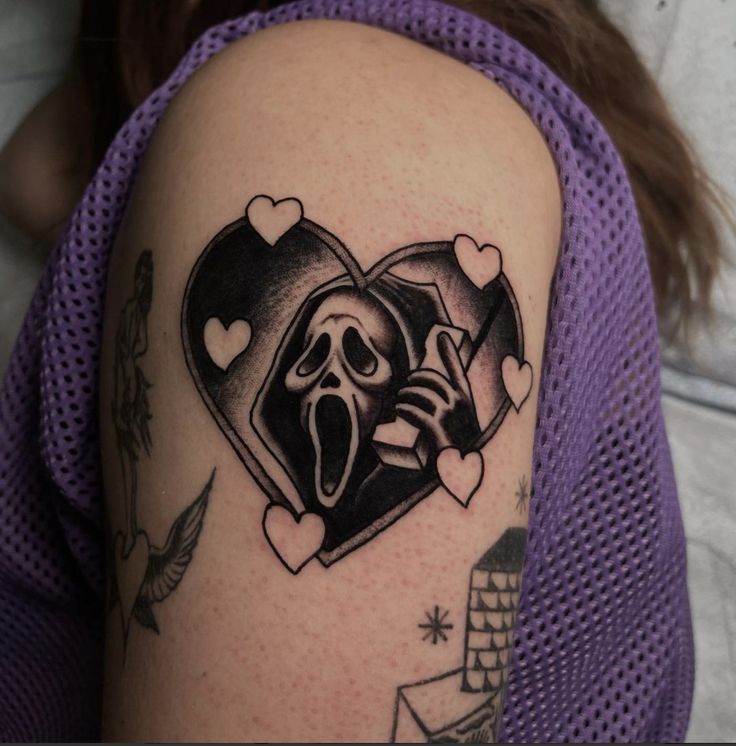 a woman's arm with a tattoo on it that has a heart and a skeleton in the middle