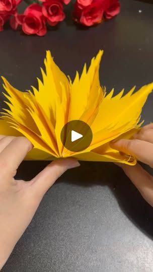 someone is making a flower out of paper