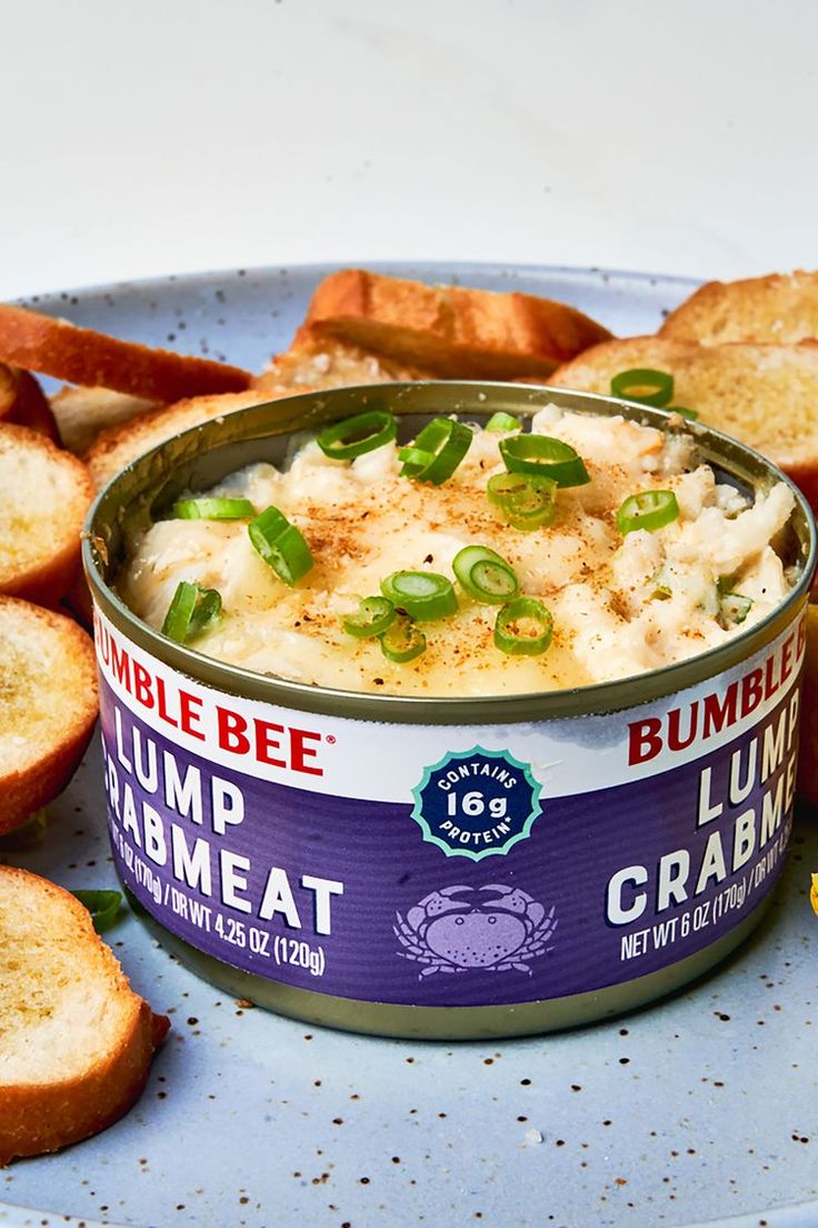 a bowl of hummus and crackers on a plate next to some bread slices