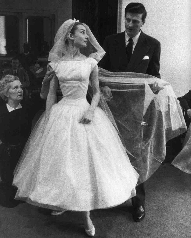 a woman in a wedding dress is standing next to a man