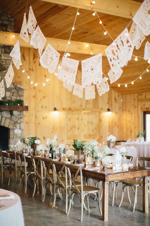 the reception tables are set up with white linens and doily hanging from the ceiling