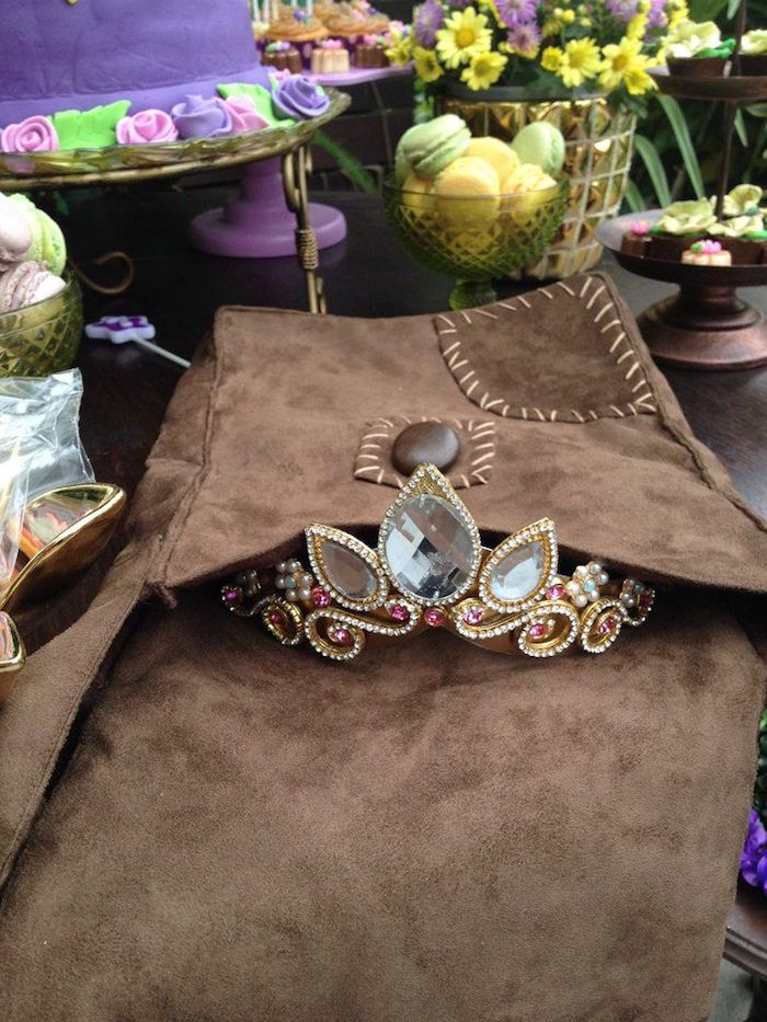 a table topped with lots of different types of jewelry on top of brown cloths