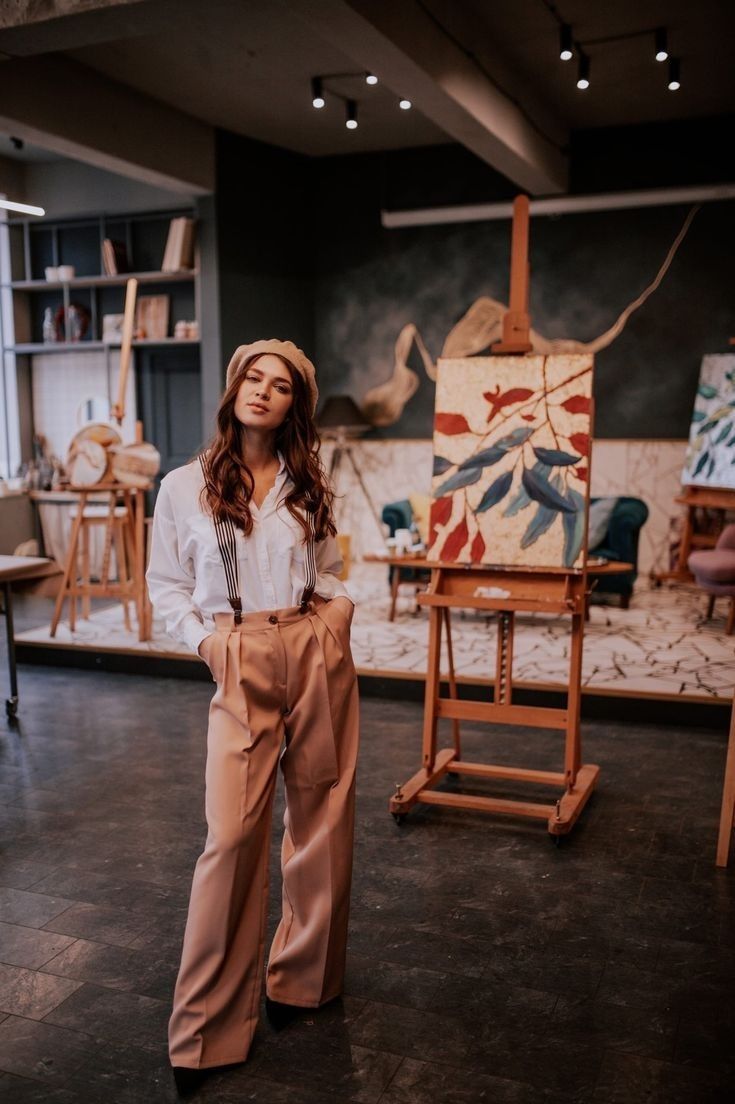 a woman standing in front of an easel