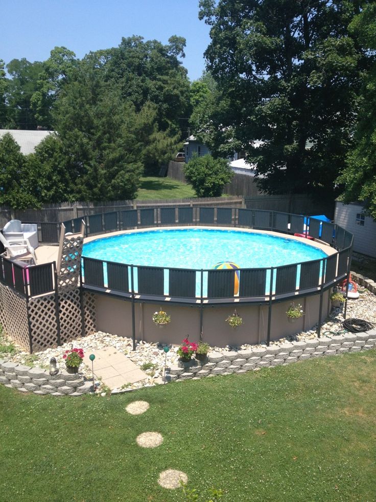 an above ground swimming pool surrounded by landscaping