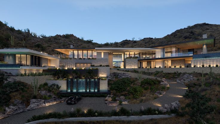 this is an image of a modern house in the mountains at night with lights on