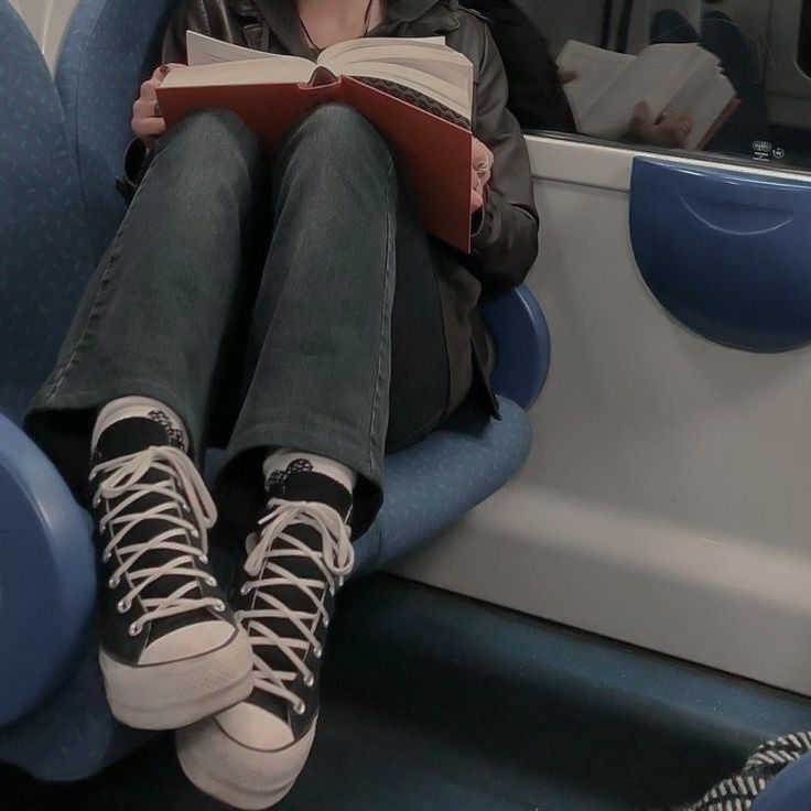 a person sitting on a bus reading a book