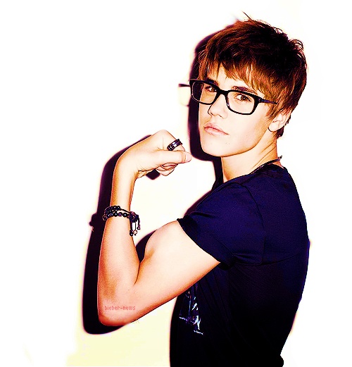 a young man with glasses posing for a photo in front of a white background wearing a black t - shirt