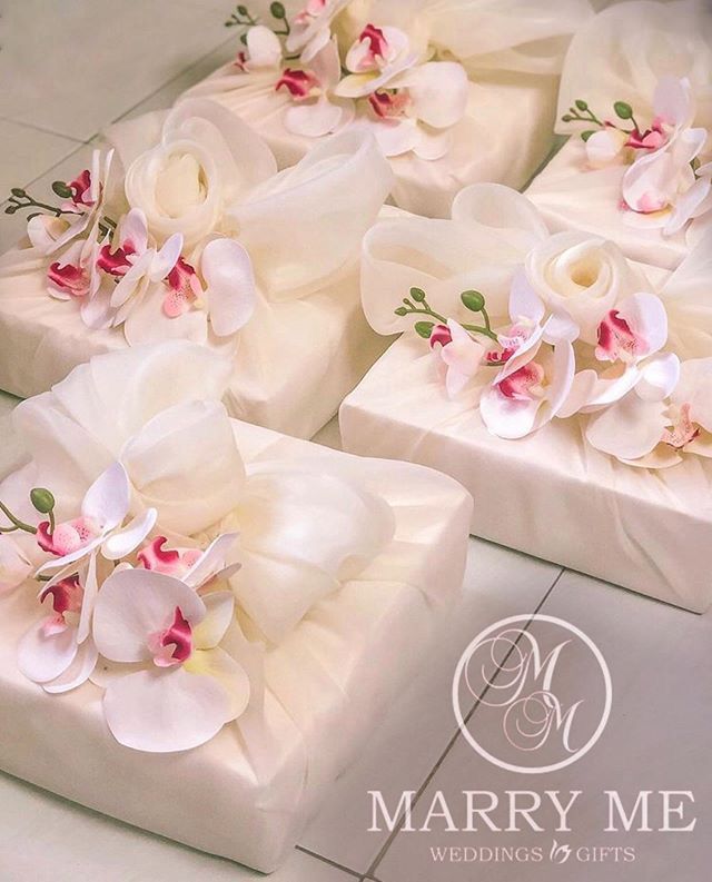 several white boxes with flowers on them sitting on a tile floor in front of a wall