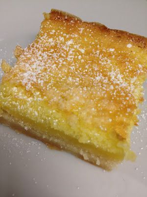 a piece of cake sitting on top of a white plate covered in powdered sugar