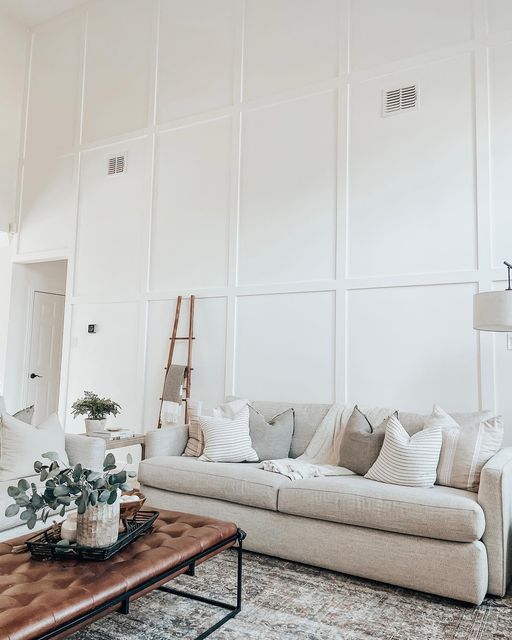 a living room filled with furniture and a large wall behind the couch is a ladder