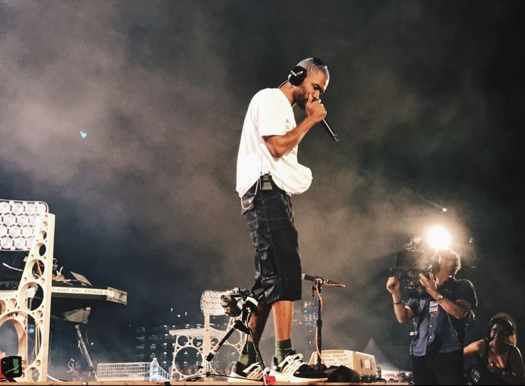 a man standing on top of a stage holding a microphone