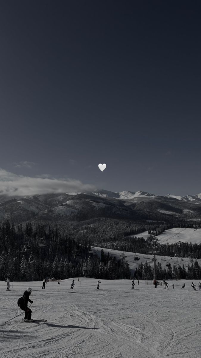 people are skiing in the snow with mountains in the background