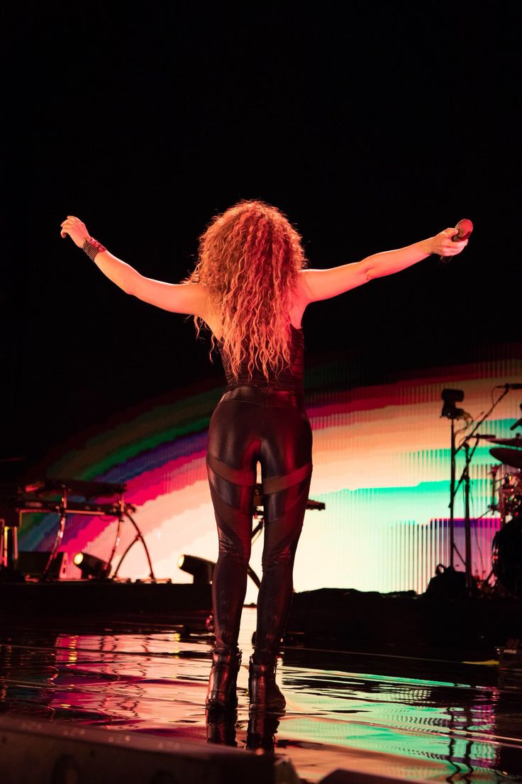 a woman with her arms outstretched on stage