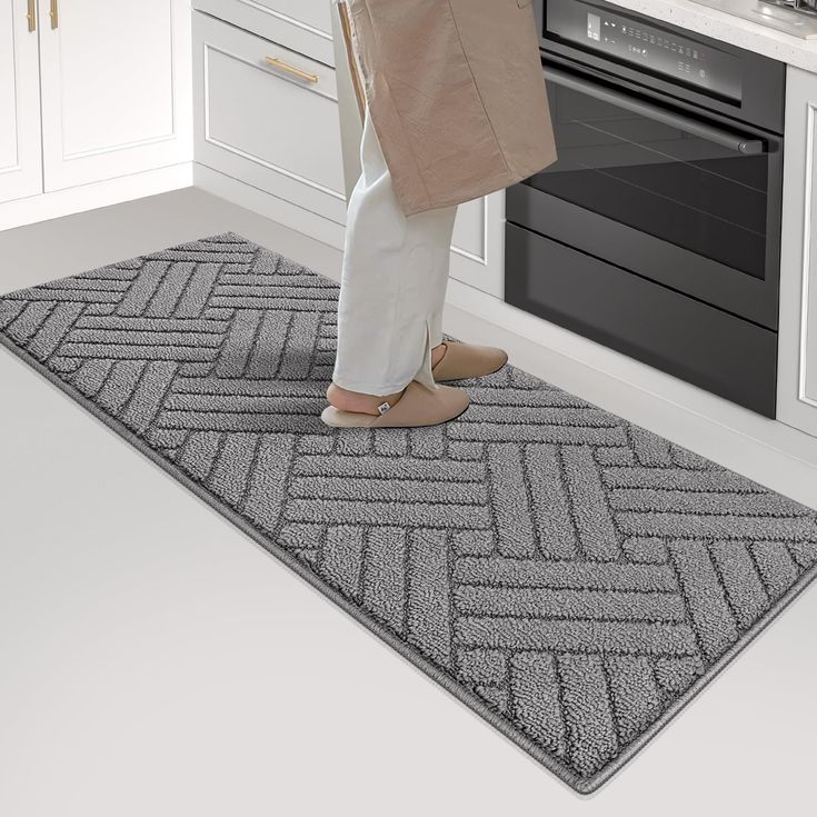 a woman is standing on the kitchen floor with her feet up and holding a shopping bag