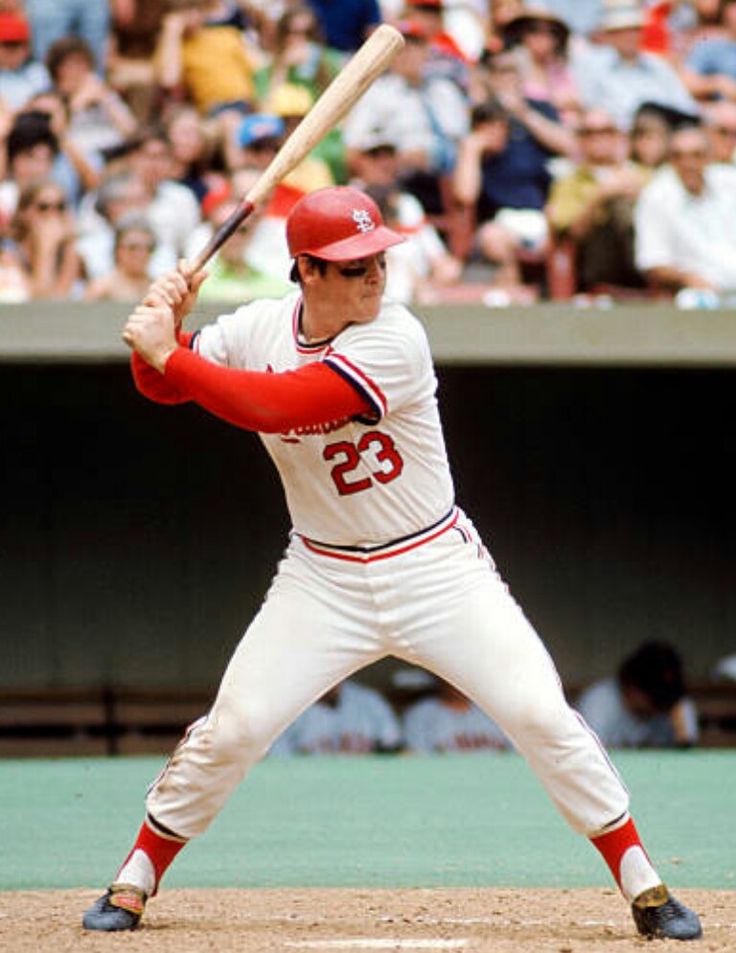 an autographed baseball player holding a bat in front of a crowd with spectators