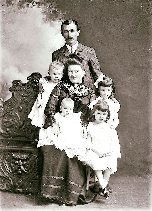 an old black and white photo of a family posing for a picture with their children