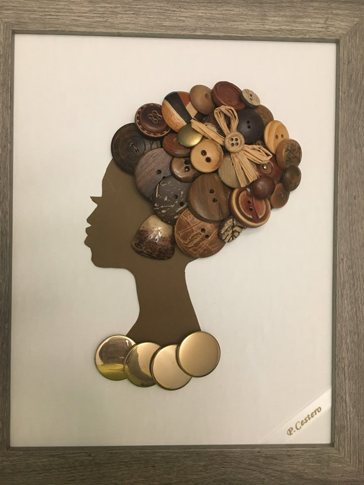 a woman's head made out of buttons in a shadow frame on the wall