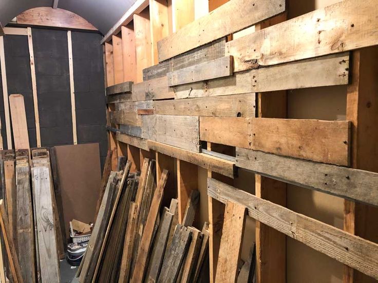 several wooden boards are stacked up against the wall