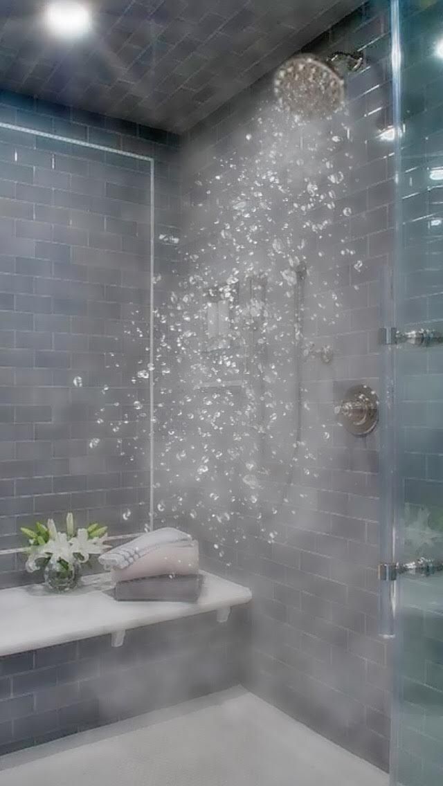 a bathroom with a glass shower door and tiled walls