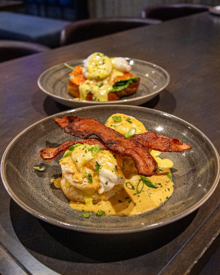 two plates filled with food on top of a wooden table