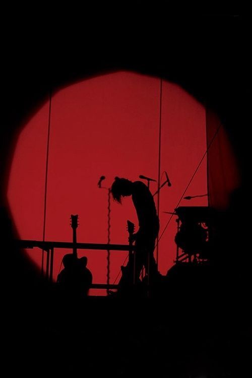 a man standing on top of a stage next to a red sun