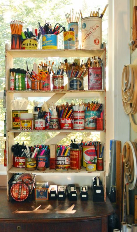 a shelf filled with lots of different types of pens and pencils next to a window