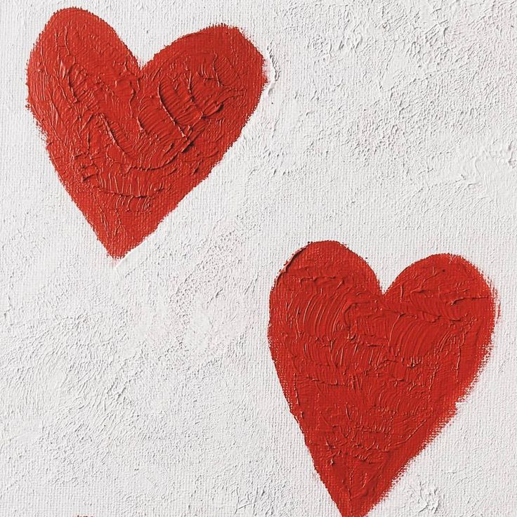 two red hearts painted on the side of a white wall