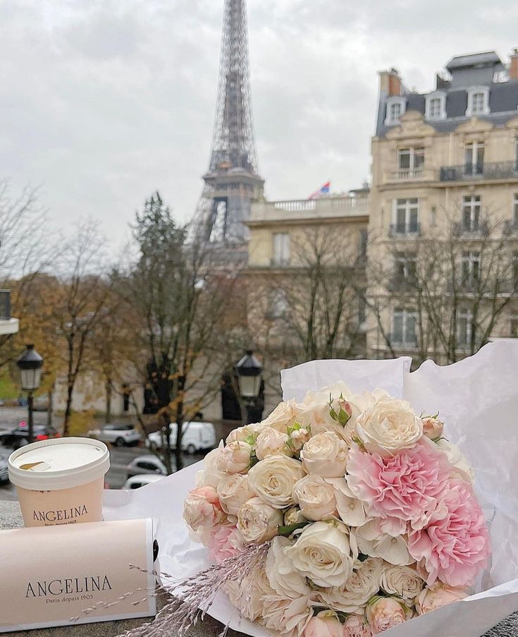 a bouquet of flowers sitting on top of a table next to a box of makeup