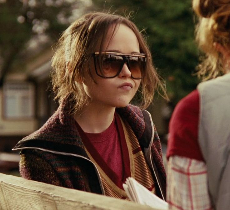 a woman in sunglasses talking to another person