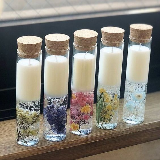 four glass bottles filled with different types of flowers