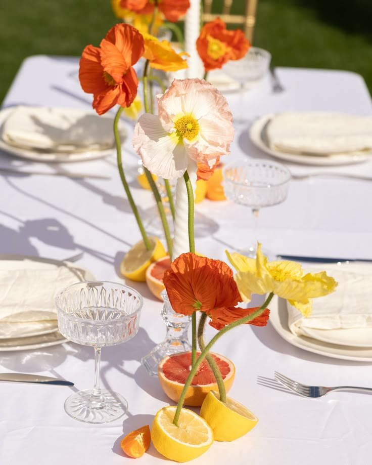 the table is set with flowers and lemons