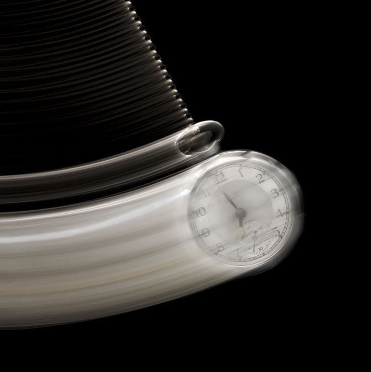 an analog clock sitting on top of a stack of stacked books in front of a black background