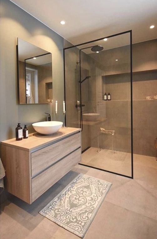 a bathroom with a sink, mirror and shower stall