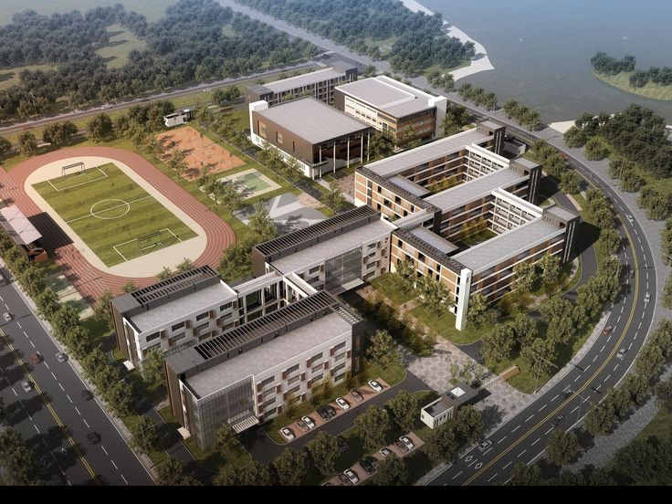 an aerial view of a soccer field and several buildings in the foreground, with a body of water in the background