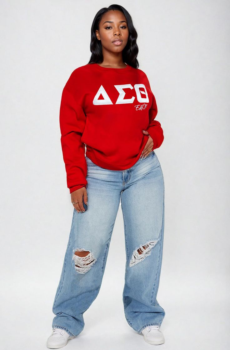 a woman wearing a red sweatshirt and ripped jeans with the word aeg on it