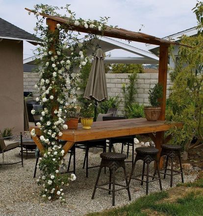 an outdoor dining area with table, chairs and umbrella