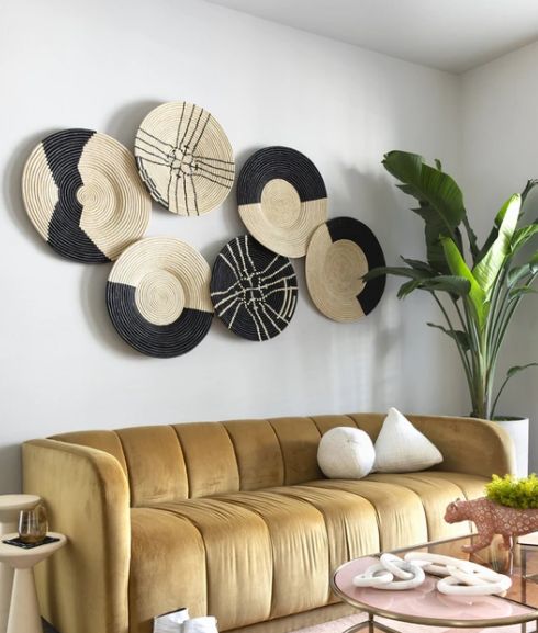 a living room filled with furniture and lots of hats hanging on the wall above it