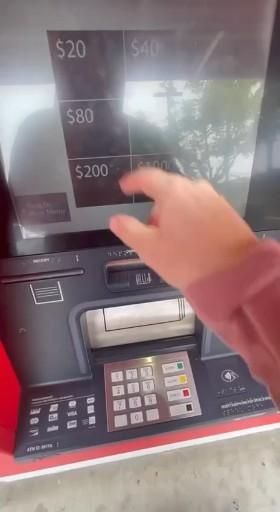 a person is using an atm machine to pay money