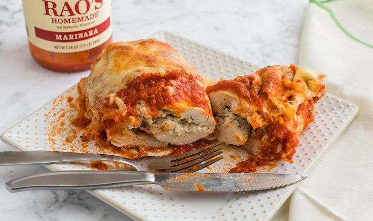 a white plate topped with lasagna covered in sauce next to a bottle of pasta