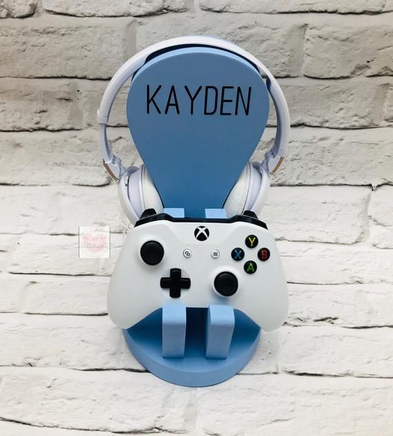 a video game controller mounted to a brick wall with the word kayden on it