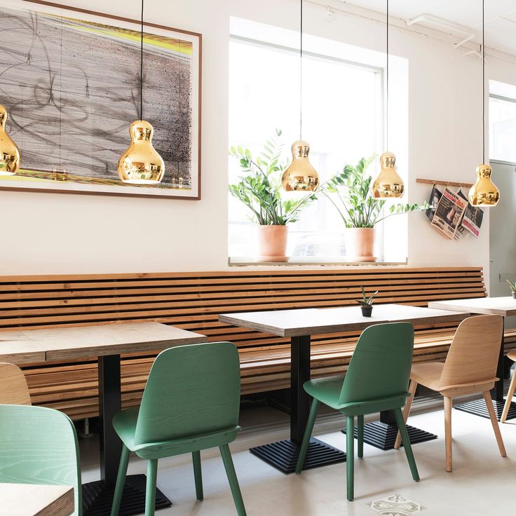 a room with tables, chairs and pictures on the wall above them that have plants in pots