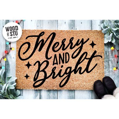 merry and bright door mat with black lettering on it next to some christmas wreaths