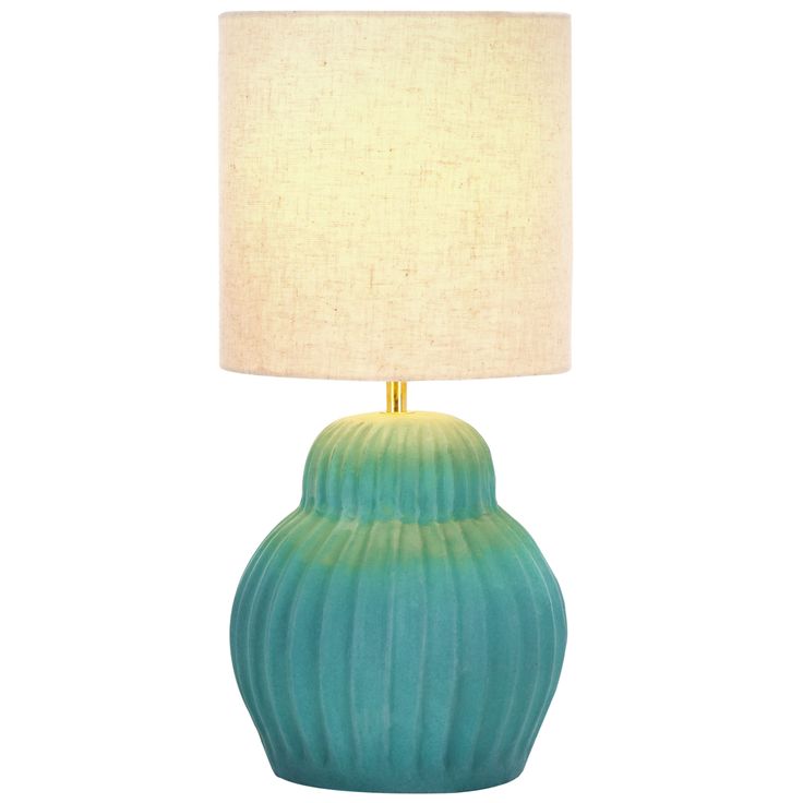 a blue lamp with a white shade on it's base and a beige linen lampshade