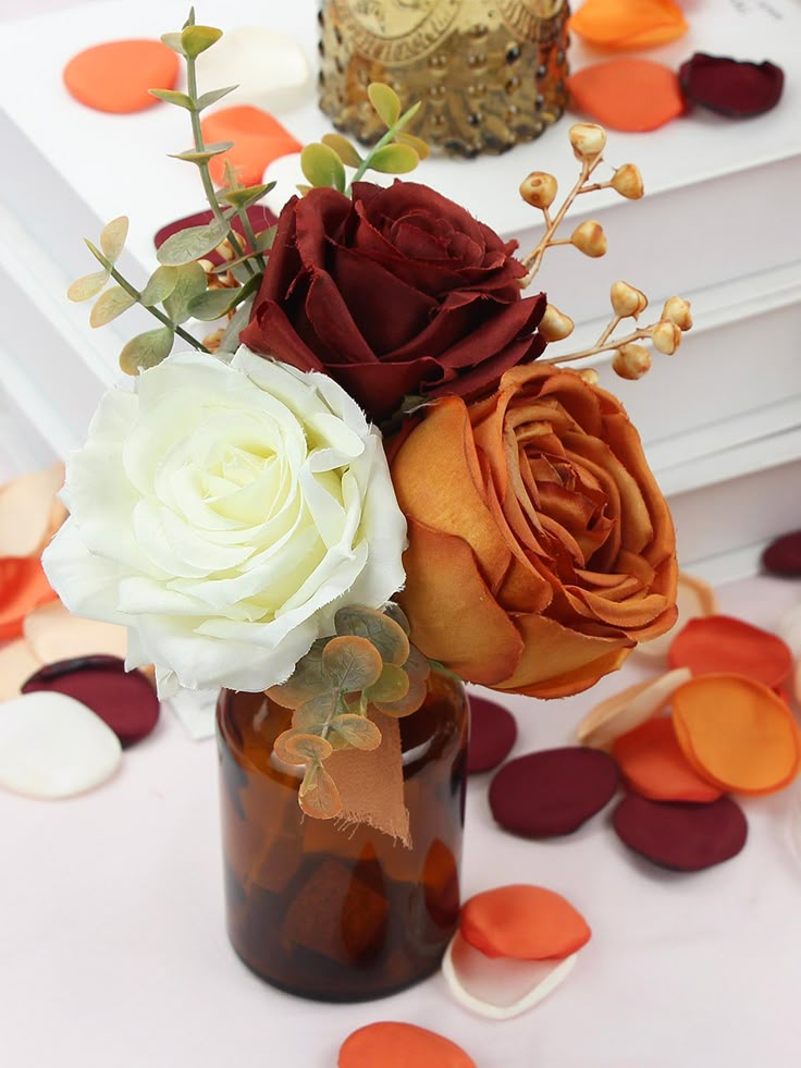 a vase filled with flowers sitting on top of a table covered in confetti