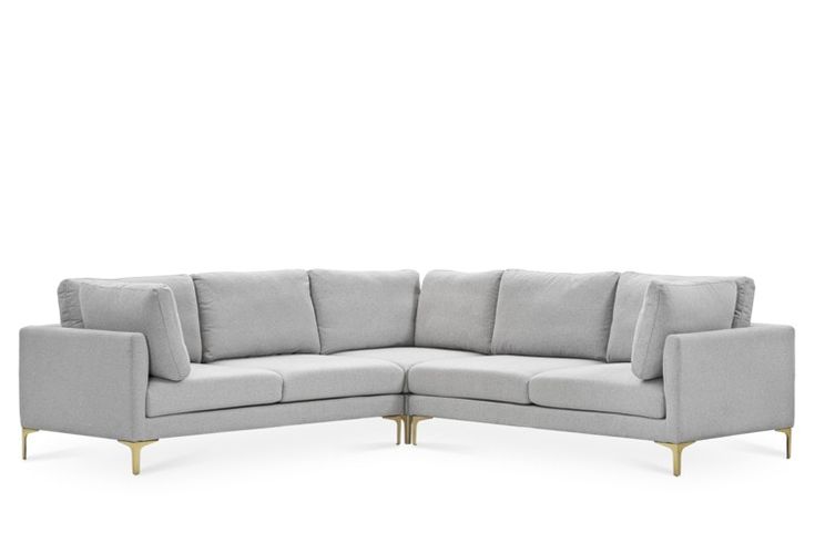 a gray sectional couch sitting on top of a white floor